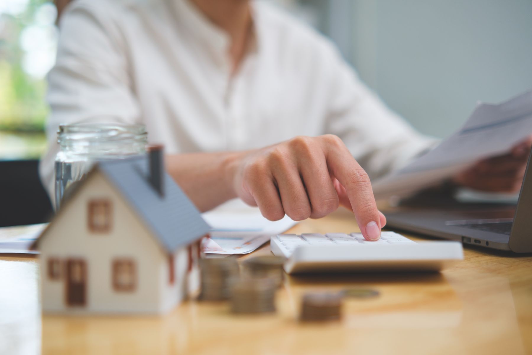Indiana homeowner using a calculator to weigh the financial decision of selling or renting their home
