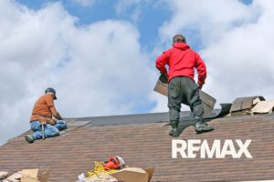 Two roofers replacing worn shingles on an Indiana home being prepped to sell
